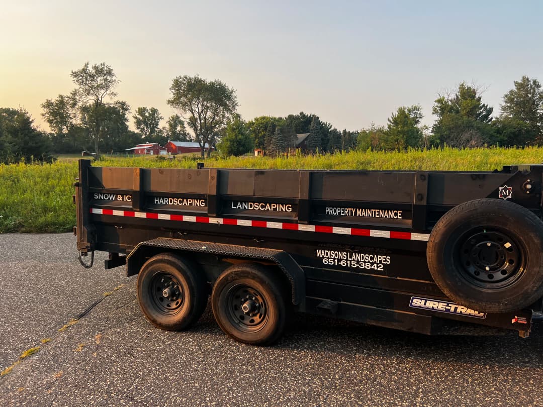 Landscaping trailer with services listed: snow removal, hardscaping, property maintenance.