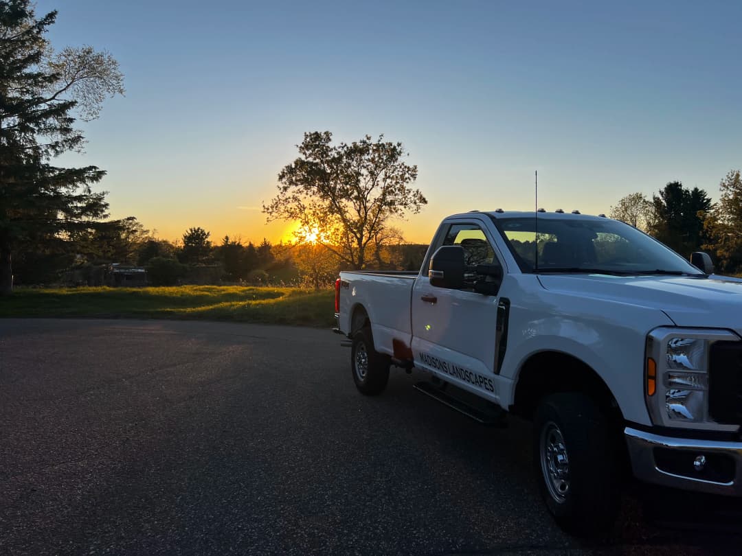 Landscaping truck parked at sunset, highlighting nature and outdoor work.