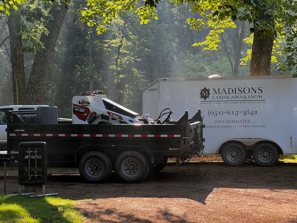 Landscape truck and trailer with snow equipment, promoting Madisons Landscapes & Snow services.