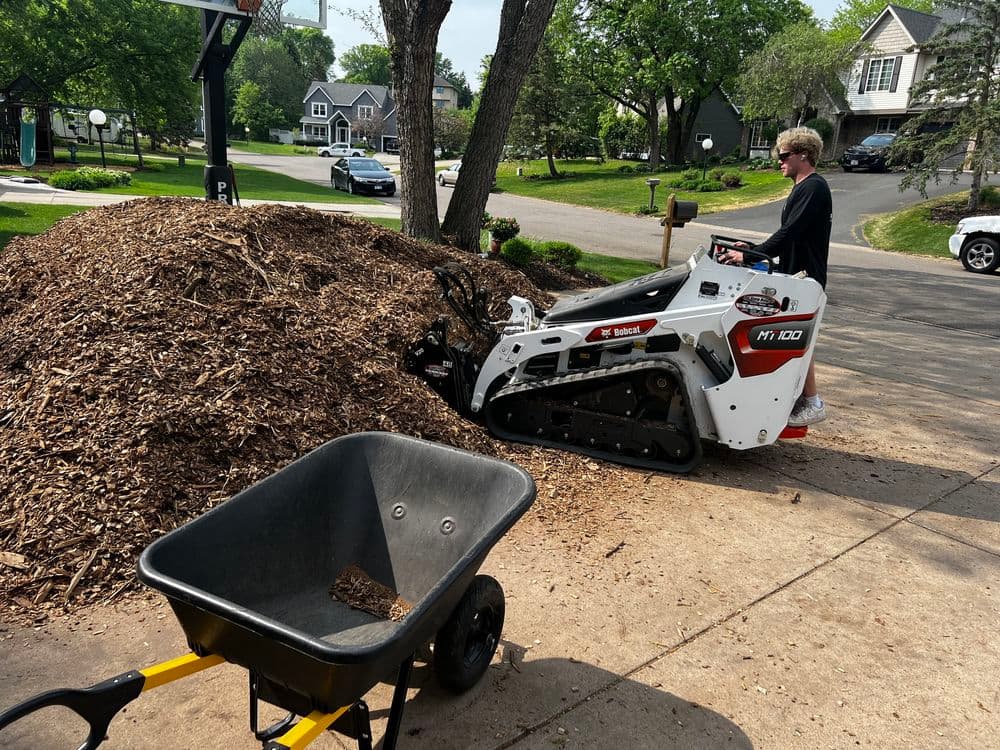 Pickup truck on a residential street beside freshly laid sod and paved walkway.