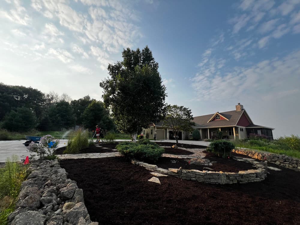 Modern home with stone landscaping and terraced garden on a sloped yard.